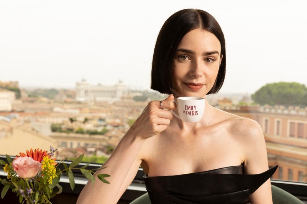 Lily Collins actrice d'Emily In Paris avec une tasse annonçant la Saison 5